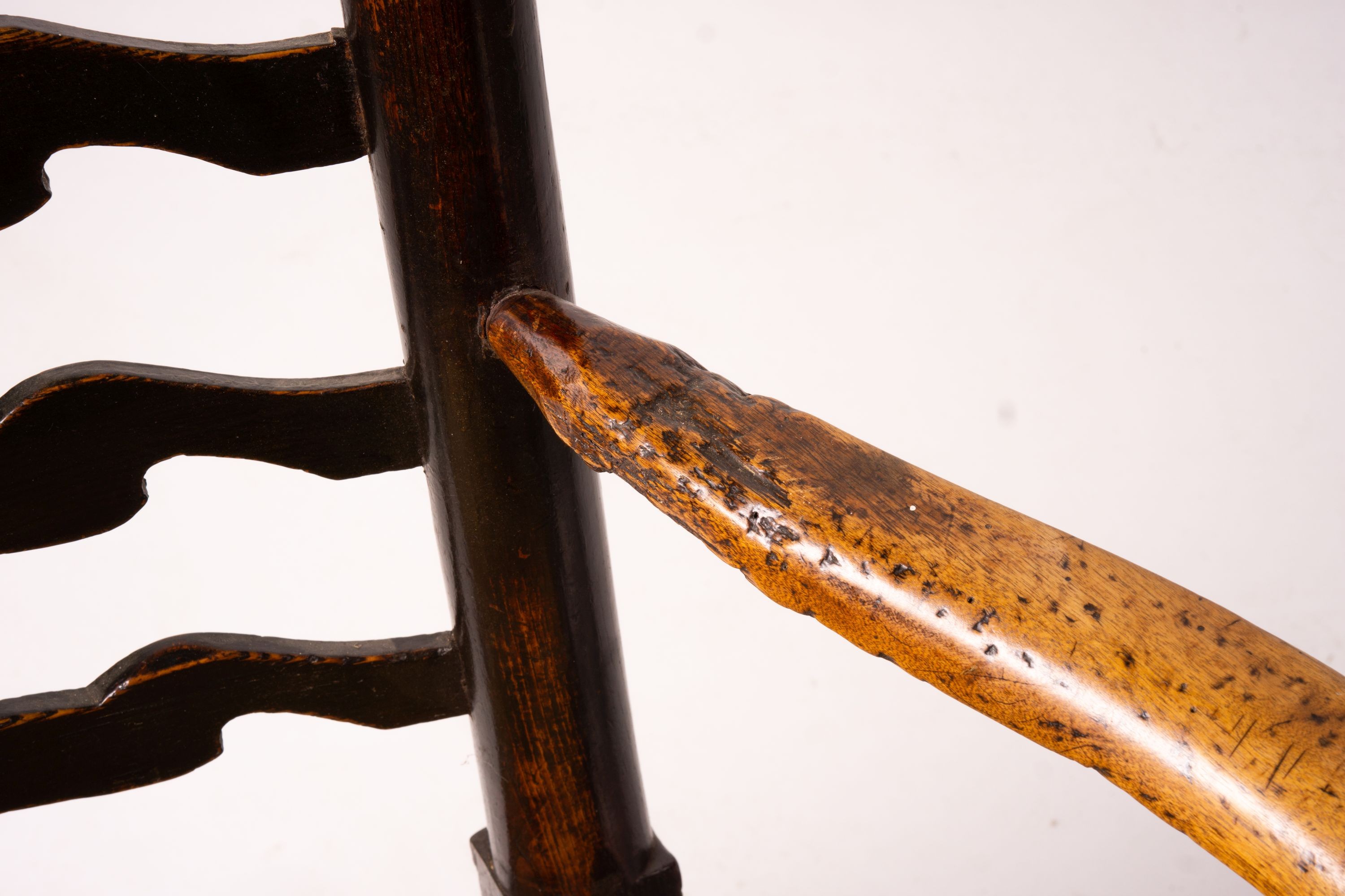 A pair of early 19th century Lancashire ash and fruitwood rush seat ladderback elbow chairs, width 60cm, depth 46cm, height 110cm